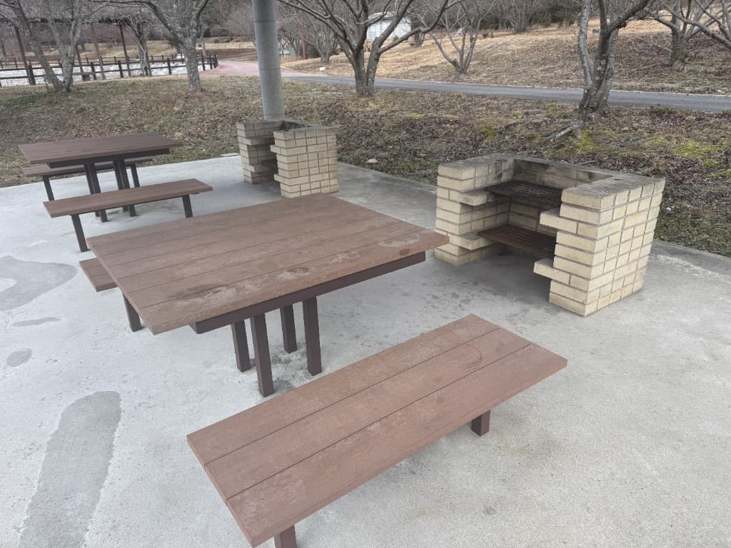 BBQサイトのレンガ造りの炉と木製テーブル・ベンチ